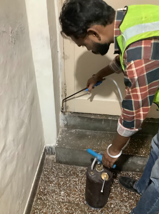 OPC technician applying termite chemical spray along door line